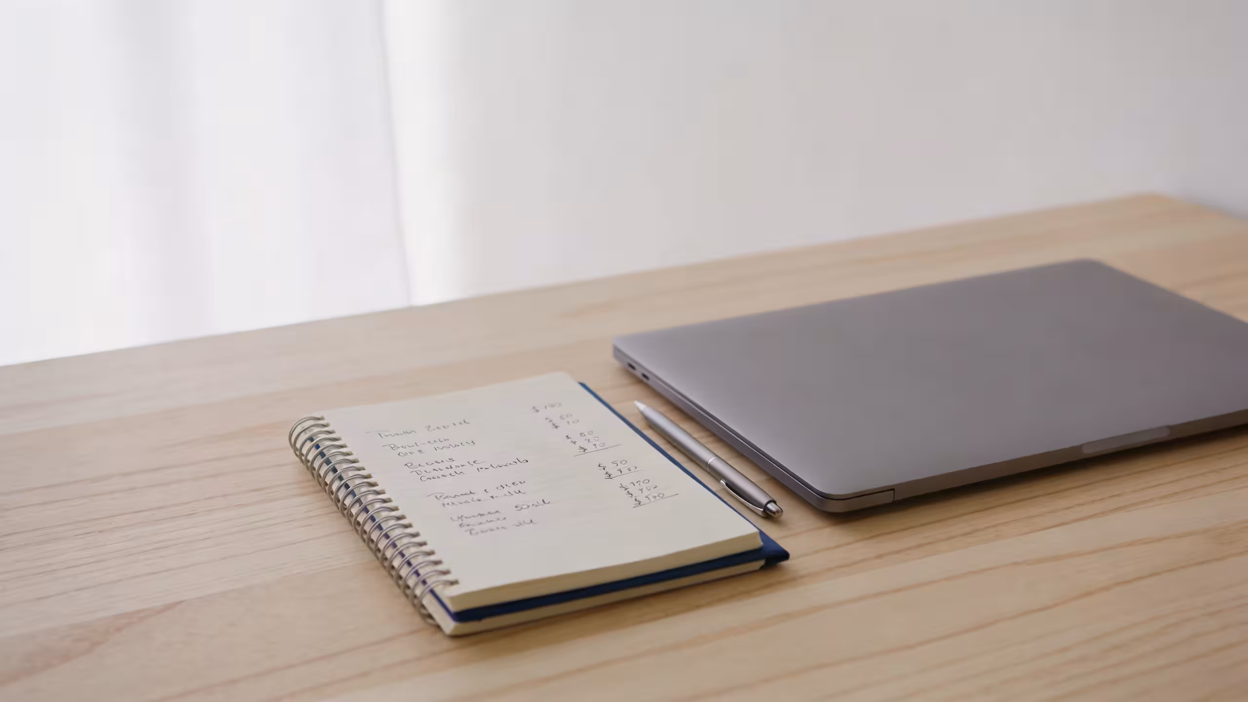 Small business loan without collateral: laptop, notebook, and pen on a clean desk representing unsecured business financing