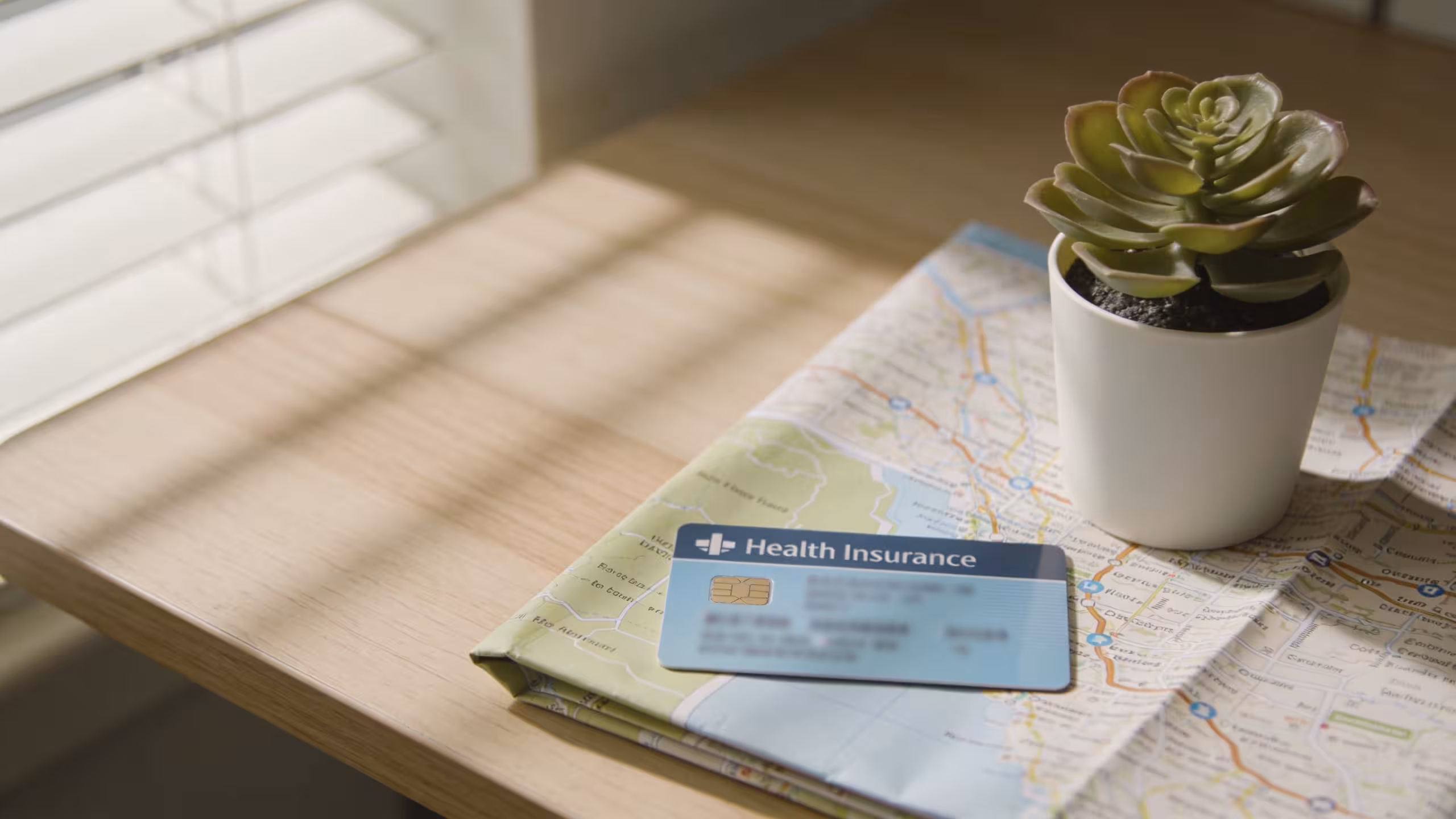 Health insurance card and medical documents on a wooden desk, soft natural light, clean professional setting, can you use health insurance in another state
