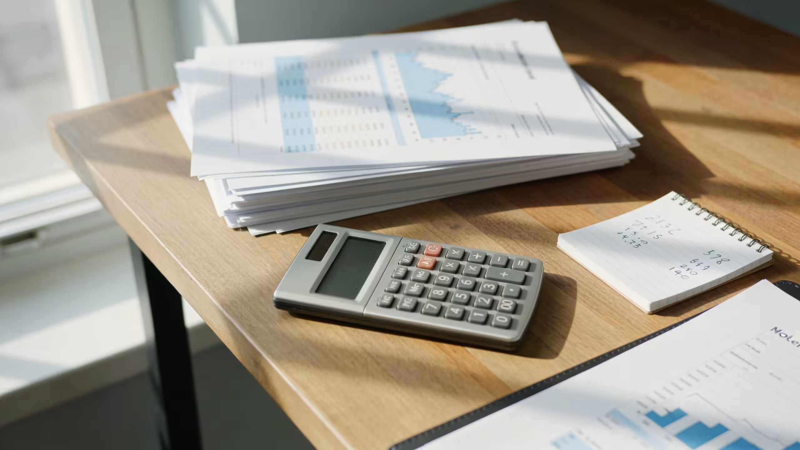 What is better than a payday loan, financial documents and a calculator on a desk, no faces, professional setting