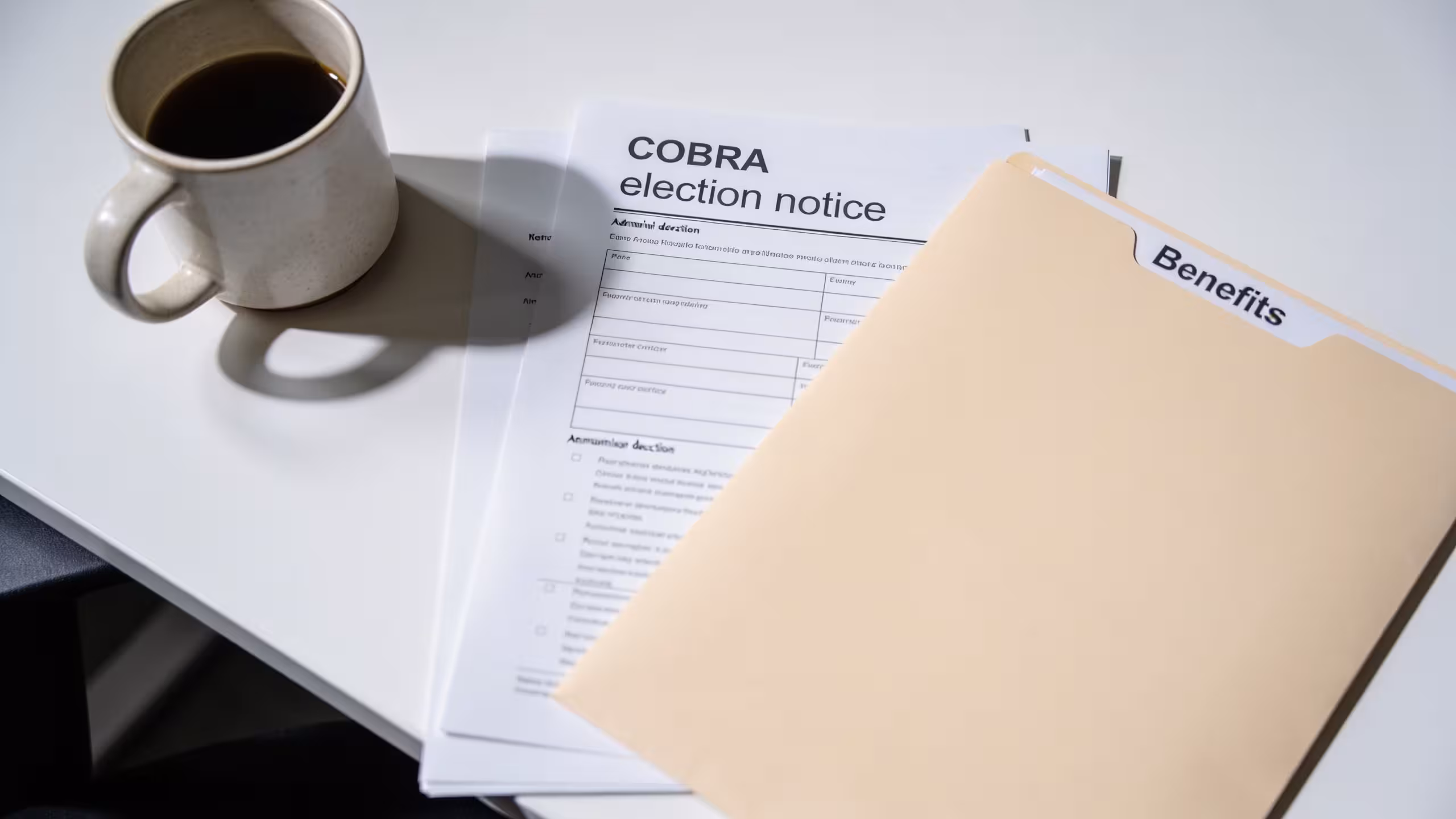 Health insurance documents and a laptop on a home office desk, health insurance after losing your job concept