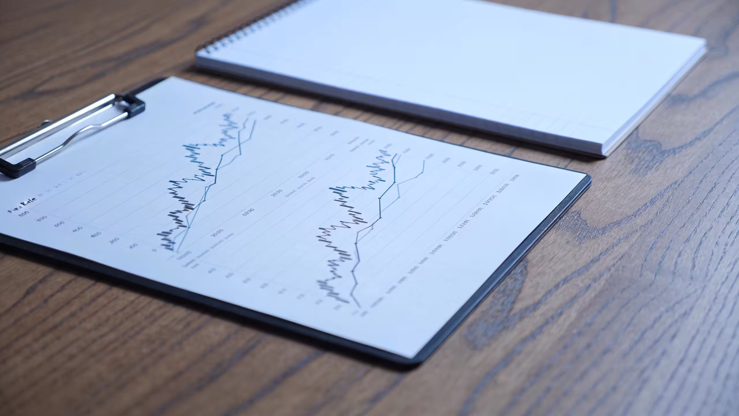 Business loan documents and interest rate chart on a clean office desk, illustrating what affects small business loan interest rates