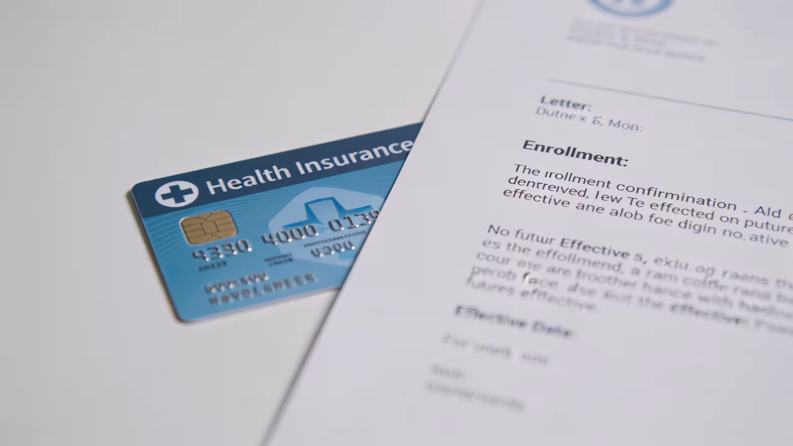 Health insurance enrollment documents and a circled calendar date on a clean desk, illustrating when health insurance starts after enrollment
