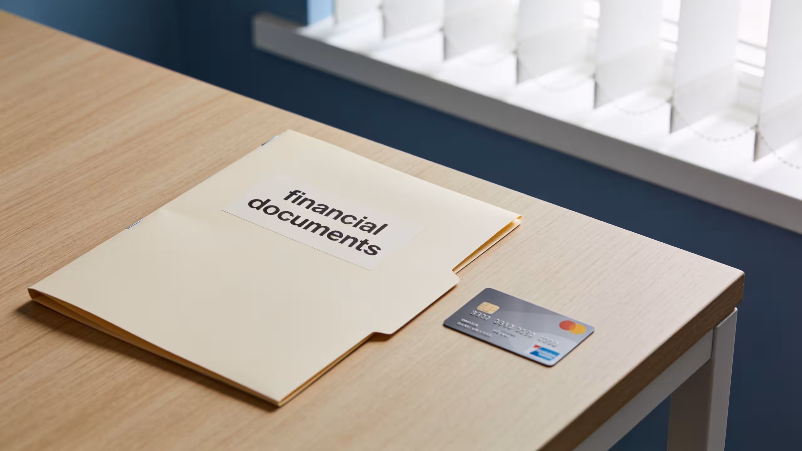 Small business loan documents and a business credit card side by side on a desk, editorial style