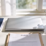 Best life insurance for young adults: laptop, notebook, and policy folder on a tidy desk