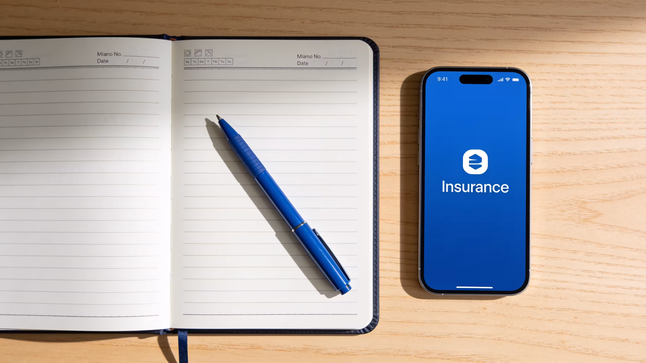 Life insurance for young adults depicted with a financial planning notebook and smartphone app on a clean desk