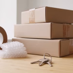 Personal loan for moving costs: moving supplies including sealed boxes, packing tape, and house keys on a wood surface
